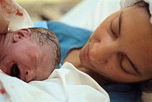 Junge Mutter mit Neugeborenem, liegend