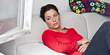 Nachdenkliche Frau sitzt auf Sofa