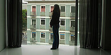 Trauernde Mutter vor bodentiefem Fenster