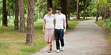 Paar spaziert Arm in Arm durch einen Park