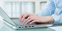 Frauenhand tippt auf einem Laptop