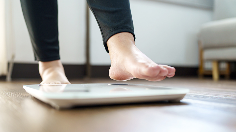 Frau steigt auf Waage